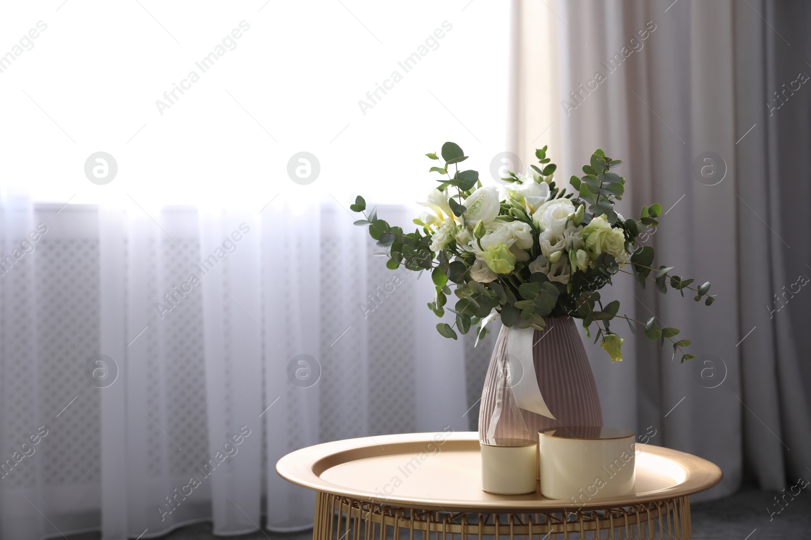 Photo of Beautiful bouquet of flowers on table in room, space for text. Stylish interior design