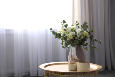Photo of Beautiful bouquet of flowers on table in room, space for text. Stylish interior design