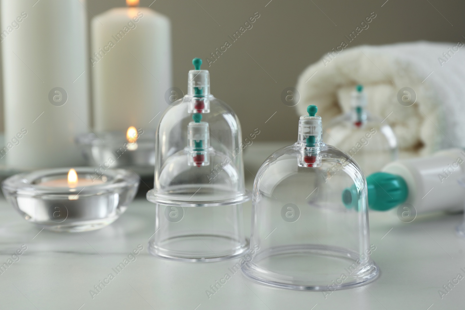 Photo of Plastic cups on white table, closeup. Cupping therapy