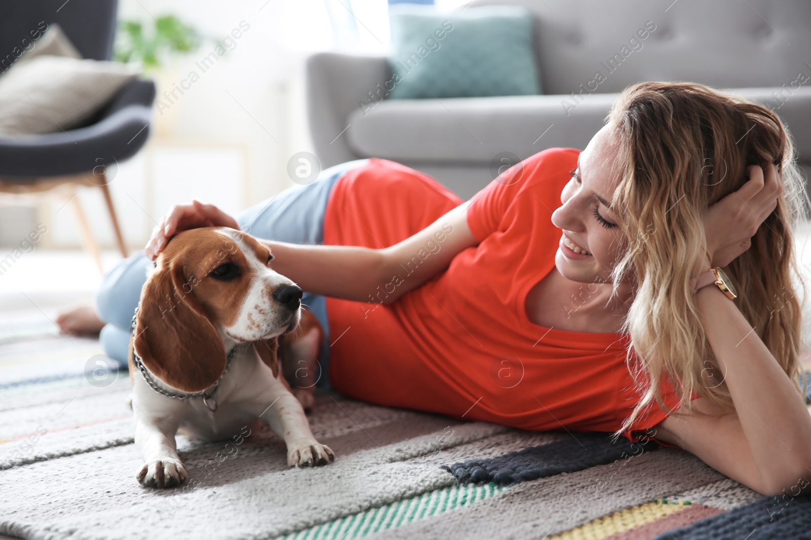 Photo of Young woman with her dog at home