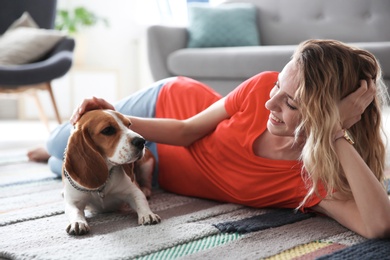 Photo of Young woman with her dog at home