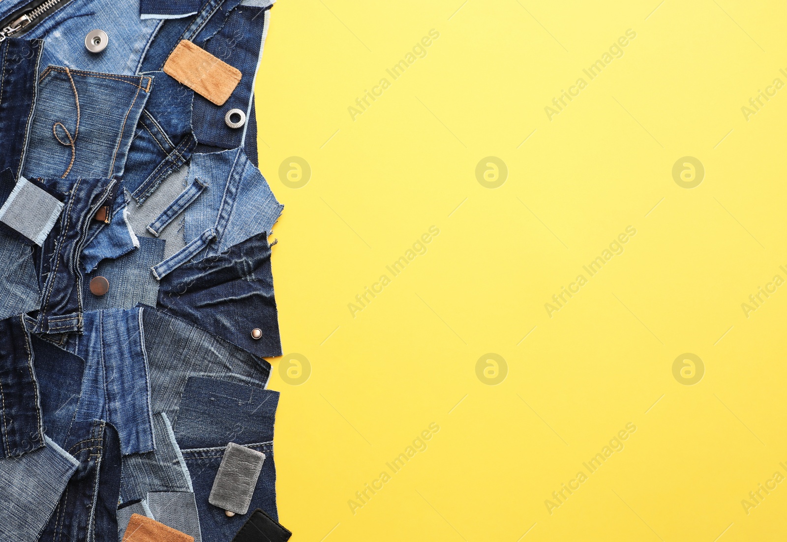 Photo of Flat lay composition with patches of old jeans on yellow background. Space for text