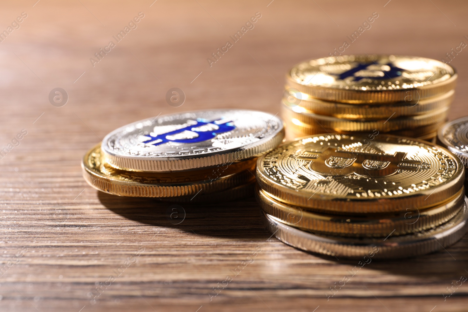 Photo of Shiny bitcoins on wooden background, space for text. Digital currency