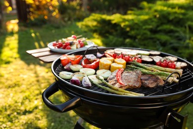 Delicious grilled vegetables and meat on barbecue grill outdoors