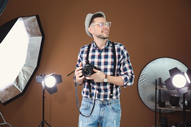 Photo of Professional photographer with camera and lighting equipment in studio
