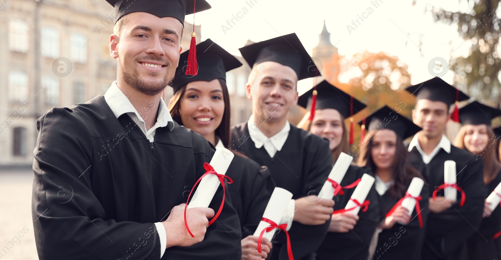 Image of Happy students with diplomas near campus. Banner design