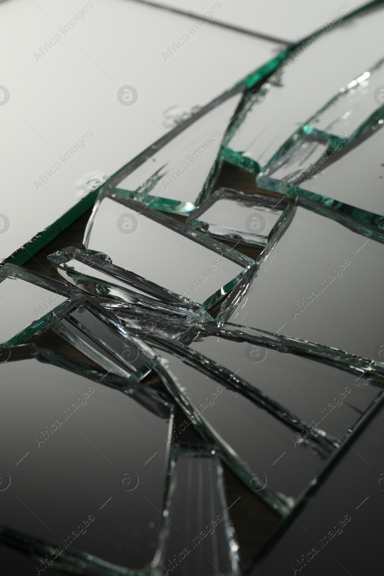 Photo of Shards of broken mirror on backing board, closeup