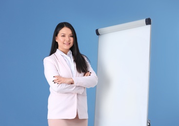 Photo of Business trainer near flip chart board against color background