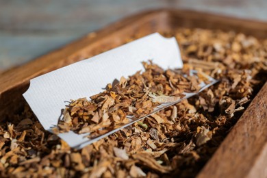 Photo of Paper and tobacco on table, closeup. Making hand rolled cigarette