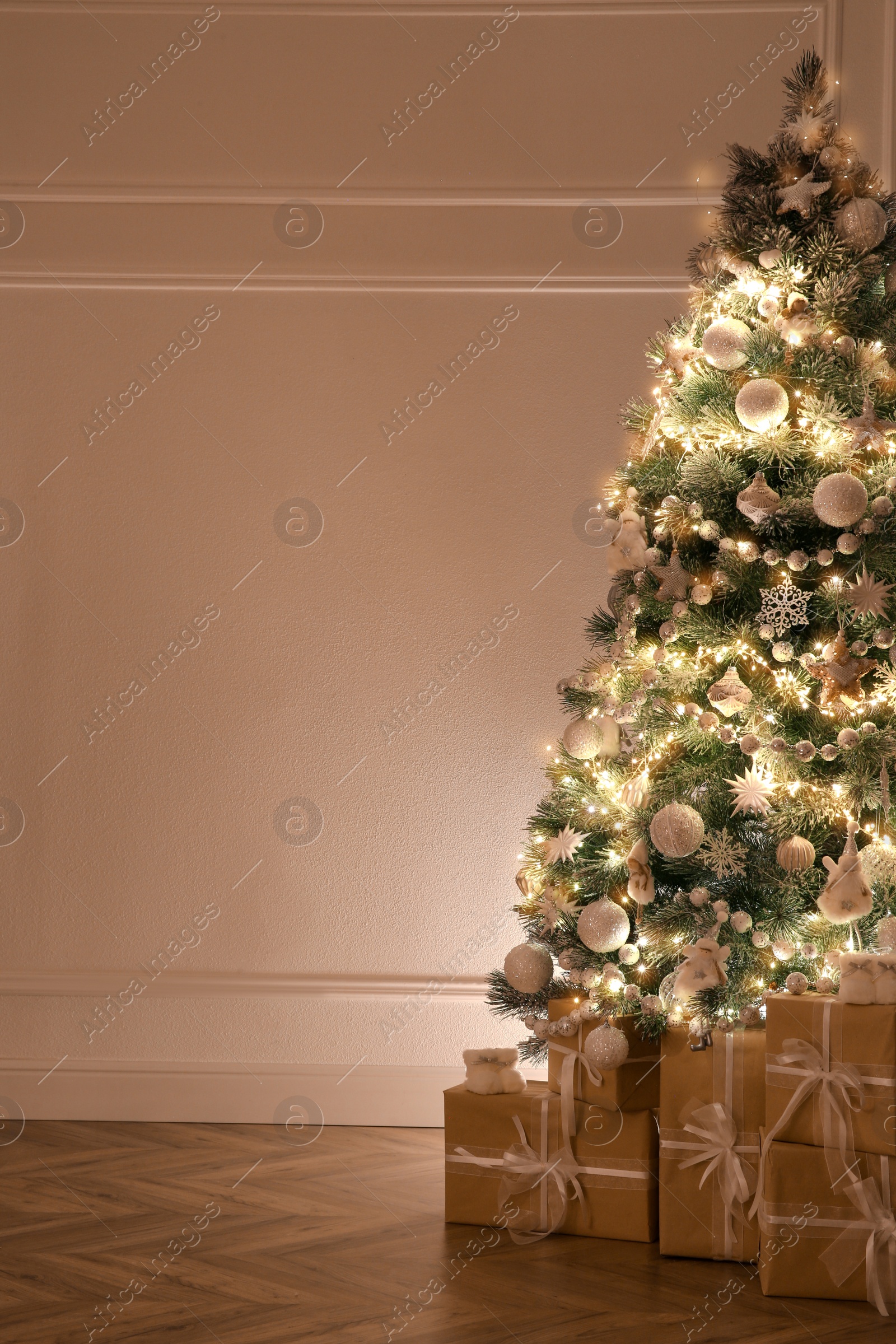 Photo of Beautiful decorated Christmas tree and gifts indoors. Space for text