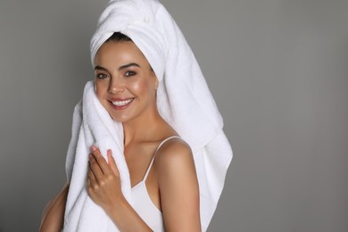 Photo of Beautiful young woman with towels on grey background