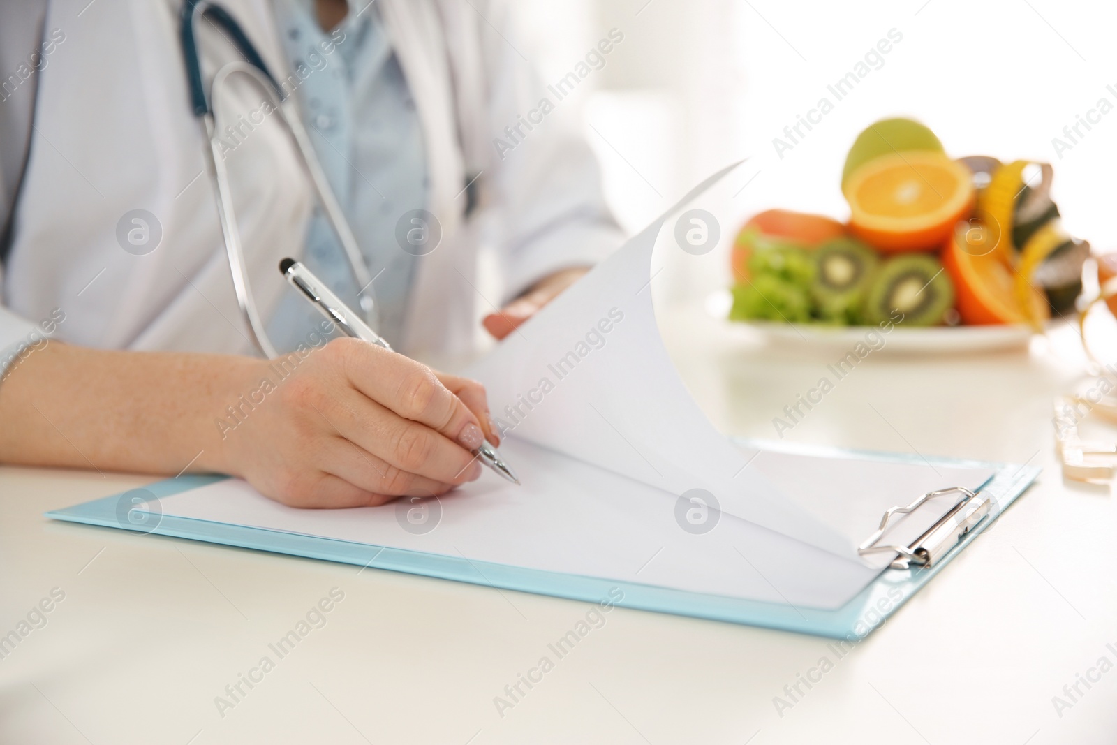 Photo of Nutritionist working at desk in office, closeup