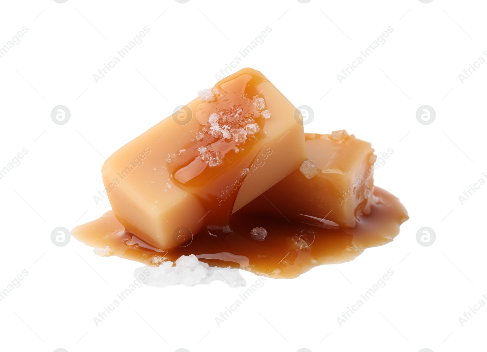 Photo of Yummy caramel candies and sea salt isolated on white