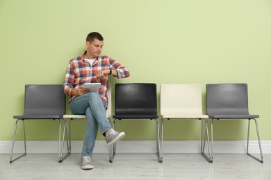 Man with tablet waiting for job interview indoors