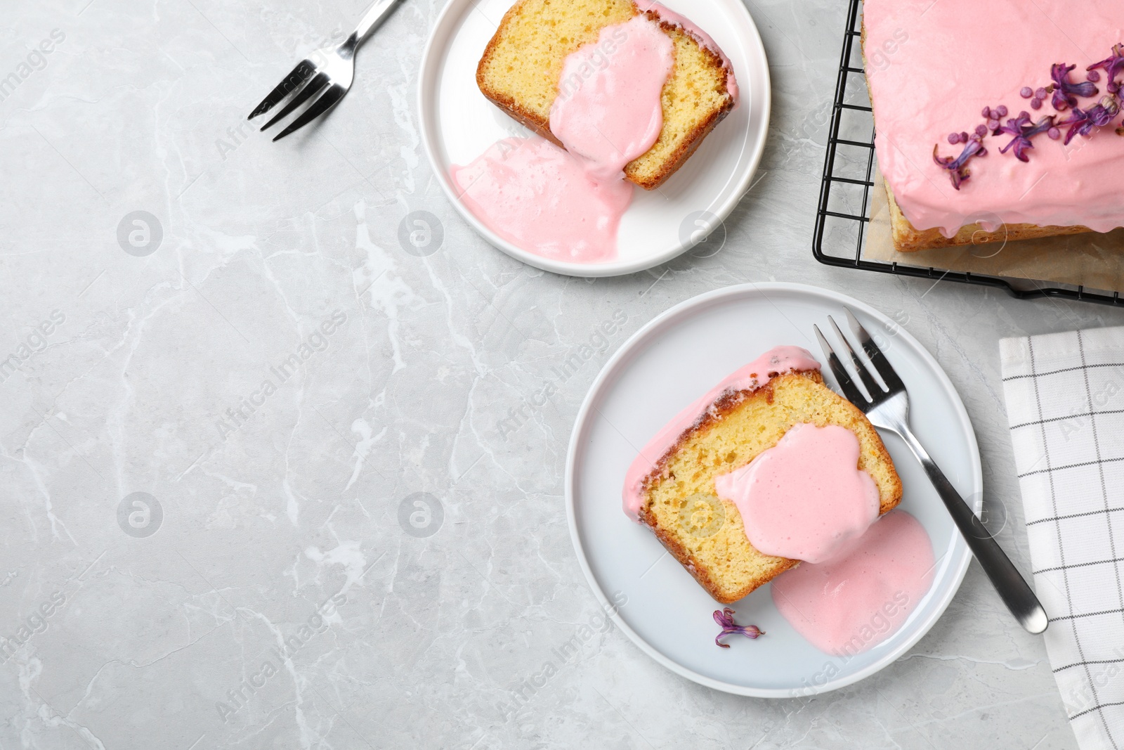 Photo of Delicious cake with pink glaze served on light marble table, flat lay. Space for text