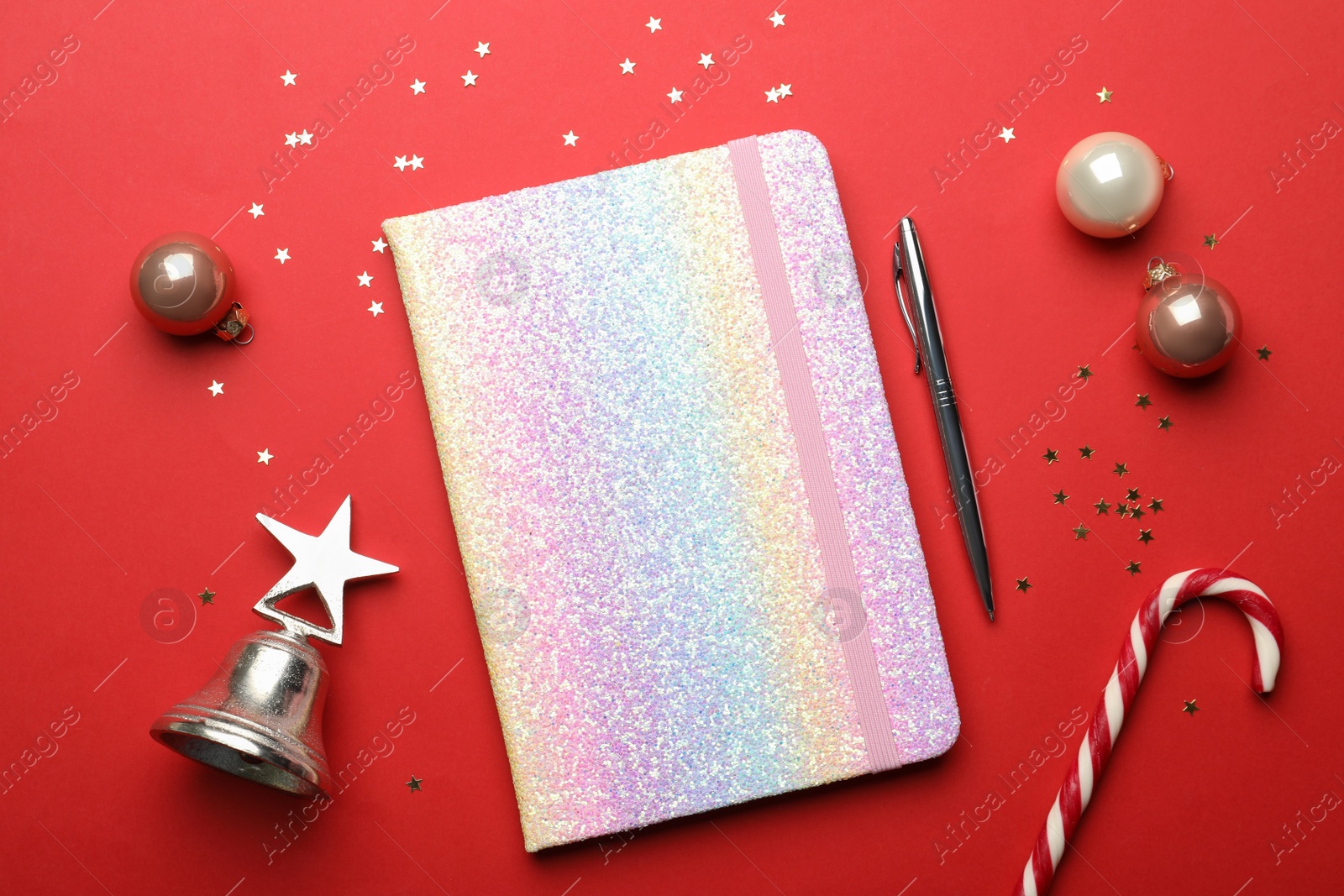 Photo of bright planner and Christmas decor on red background, flat lay