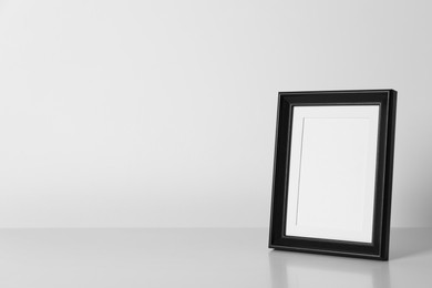 Photo of Empty square frame on white table, space for text