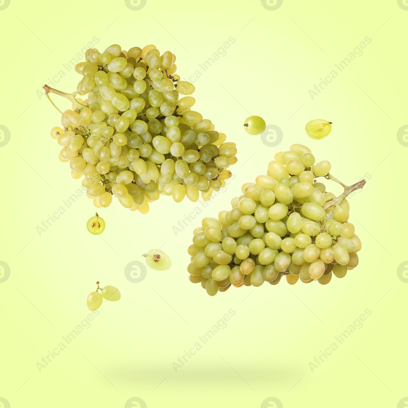 Image of Fresh grapes in air on light green background