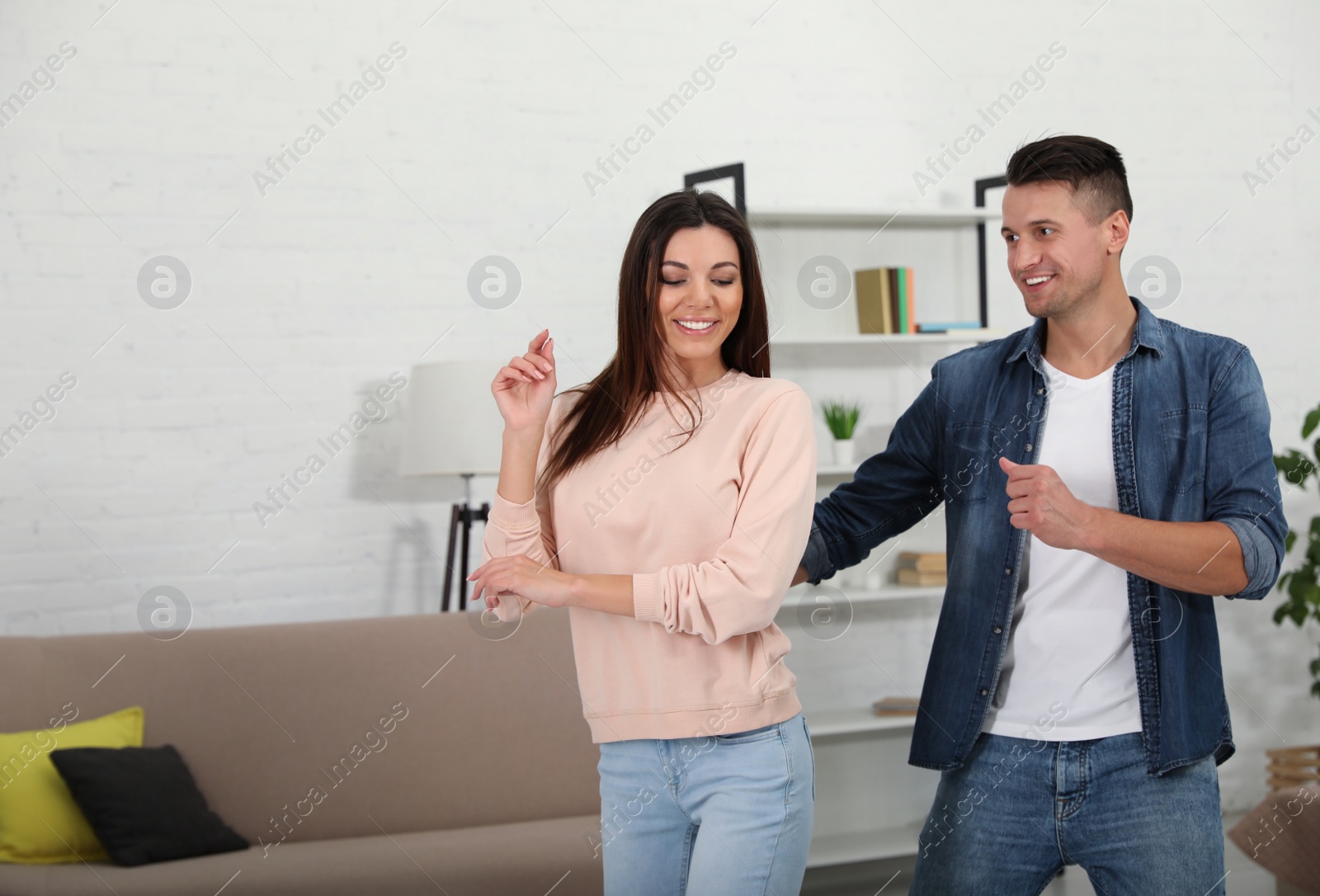 Photo of Happy couple dancing in living room at home