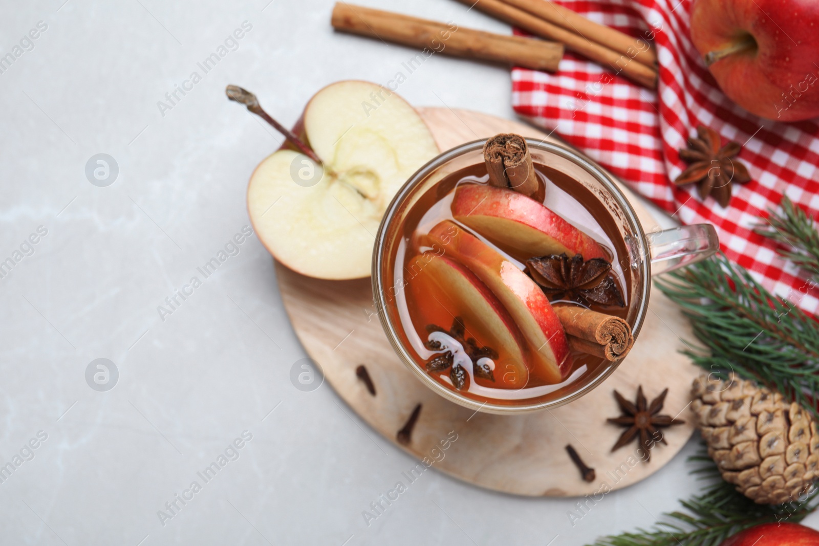 Photo of Aromatic hot mulled cider on light grey marble table, flat lay. Space for text