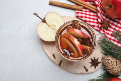 Photo of Aromatic hot mulled cider on light grey marble table, flat lay. Space for text