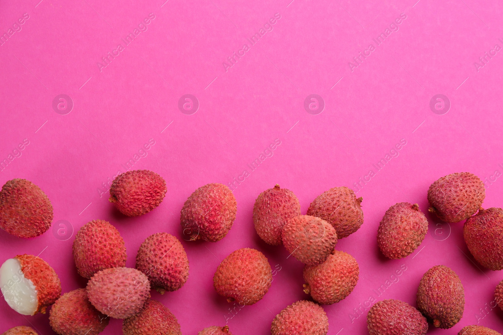 Photo of Fresh ripe lychees on pink background, flat lay. Space for text