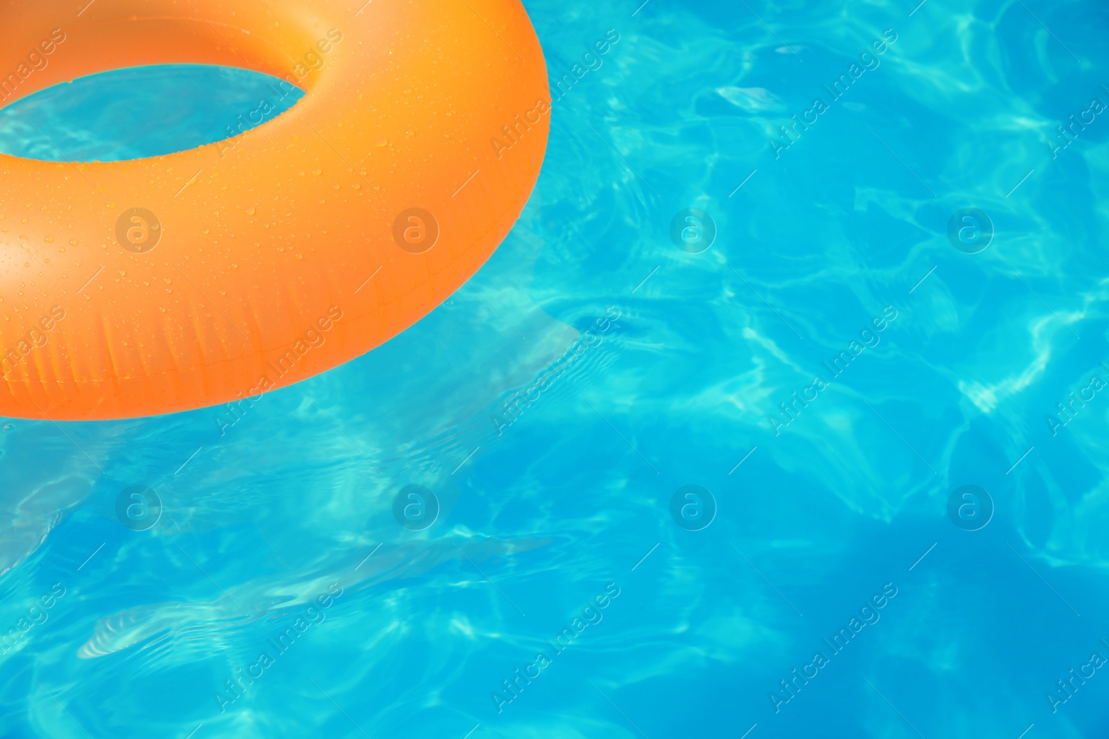 Photo of Inflatable ring floating in swimming pool on sunny day. Space for text