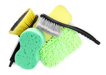Car wash mitt, sponges and brushes on white background, top view