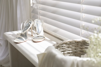 Beautiful wedding shoes on window sill indoors