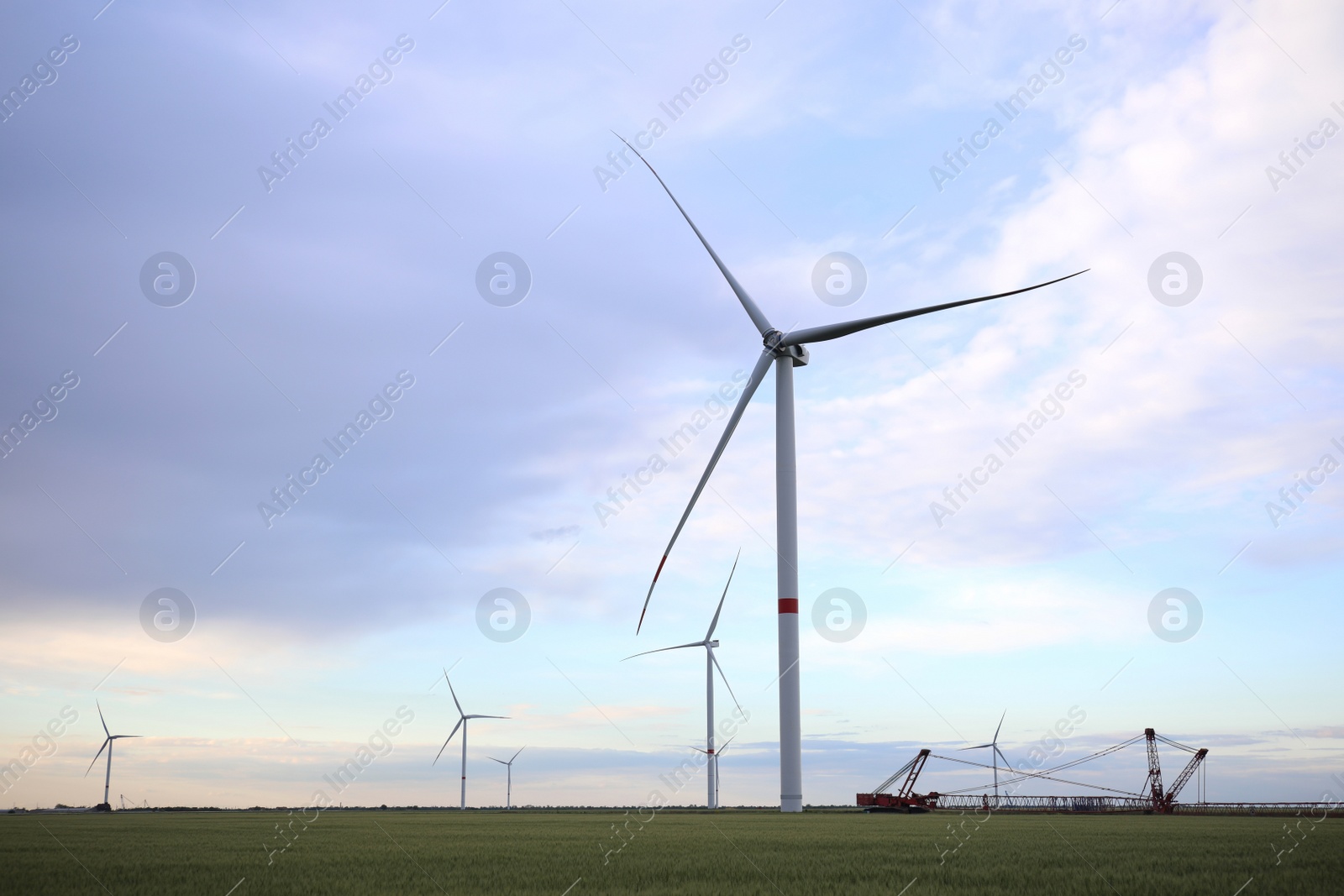 Photo of Beautiful view of field with wind turbines in evening. Alternative energy source