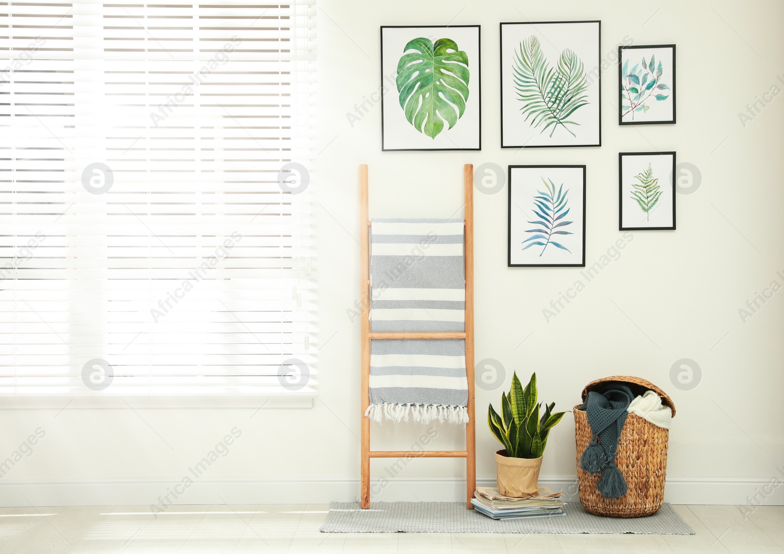 Photo of Beautiful paintings of tropical leaves on white wall in room interior