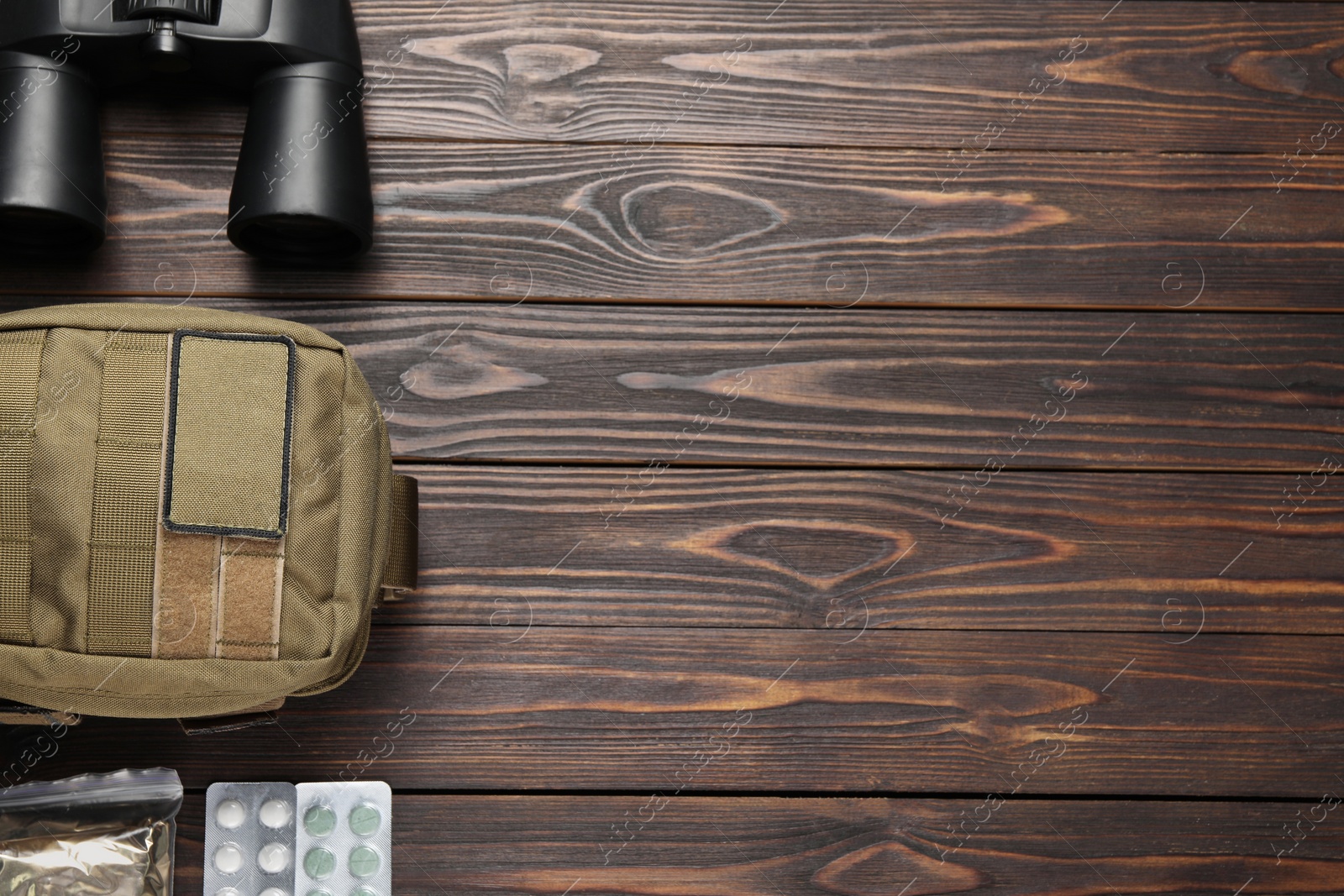 Photo of Military first aid kit on wooden table, flat lay. Space for text