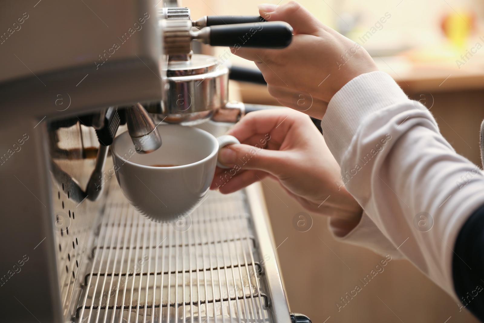 Photo of Barista preparing coffee using modern machine, closeup