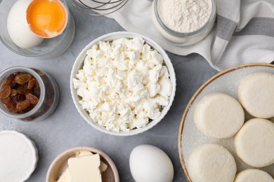 Photo of Uncooked cottage cheese pancakes and different ingredients on light grey table, flat lay