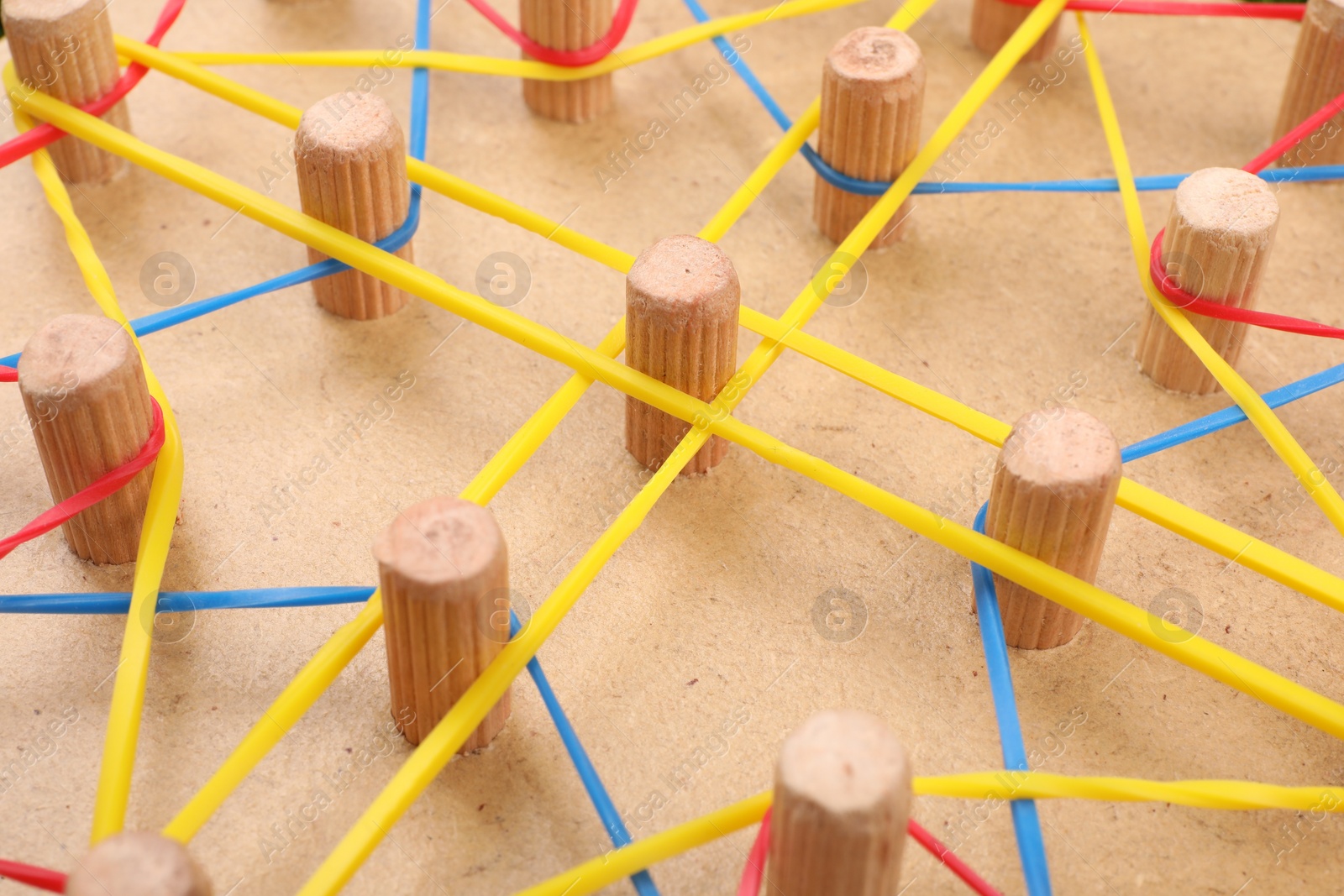 Photo of Wooden geoboard with rubber bands, closeup. Educational toy for motor skills development