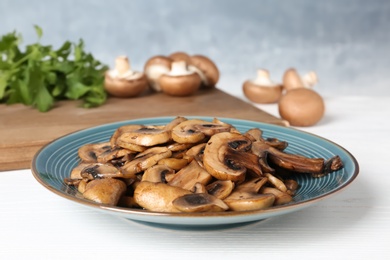 Photo of Plate of fried mushrooms on table, closeup