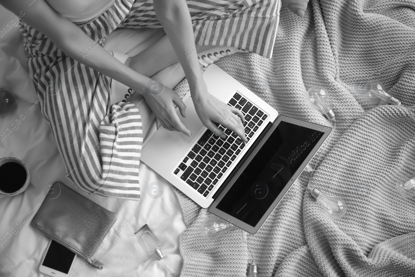 Photo of Female blogger with laptop on bed, black and white effect