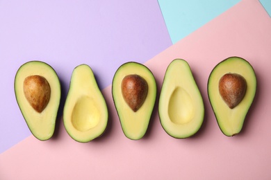 Photo of Cut fresh ripe avocados on color background, flat lay