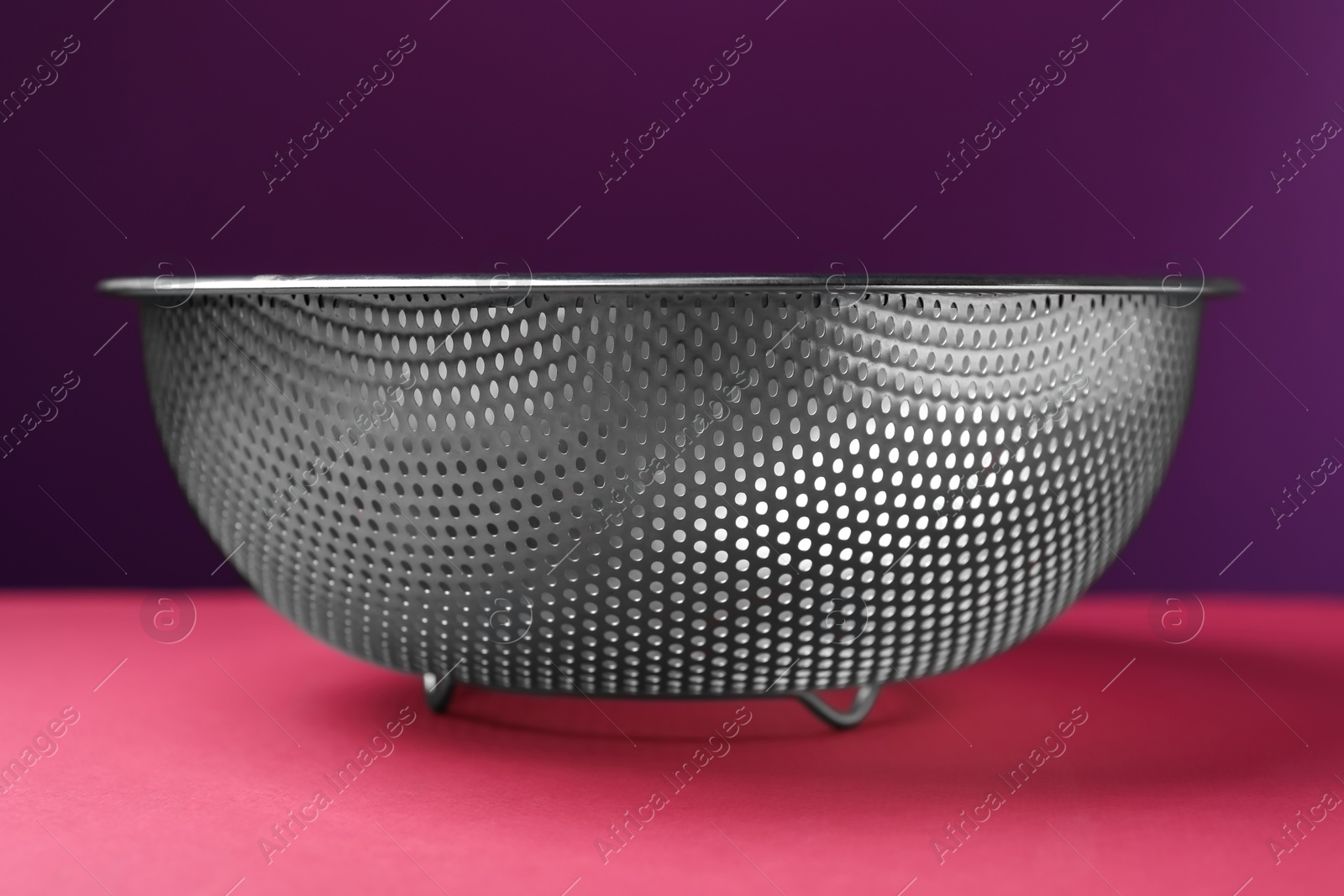 Photo of One clean empty colander on color background, closeup