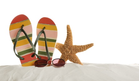 Photo of Sunglasses, flip flops and starfish on sand against white background. Beach accessories