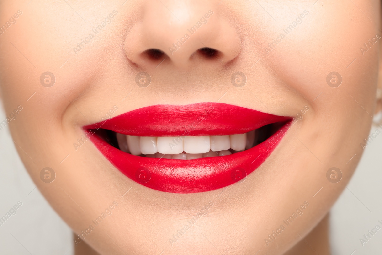 Photo of Smiling woman with healthy teeth on light background, closeup