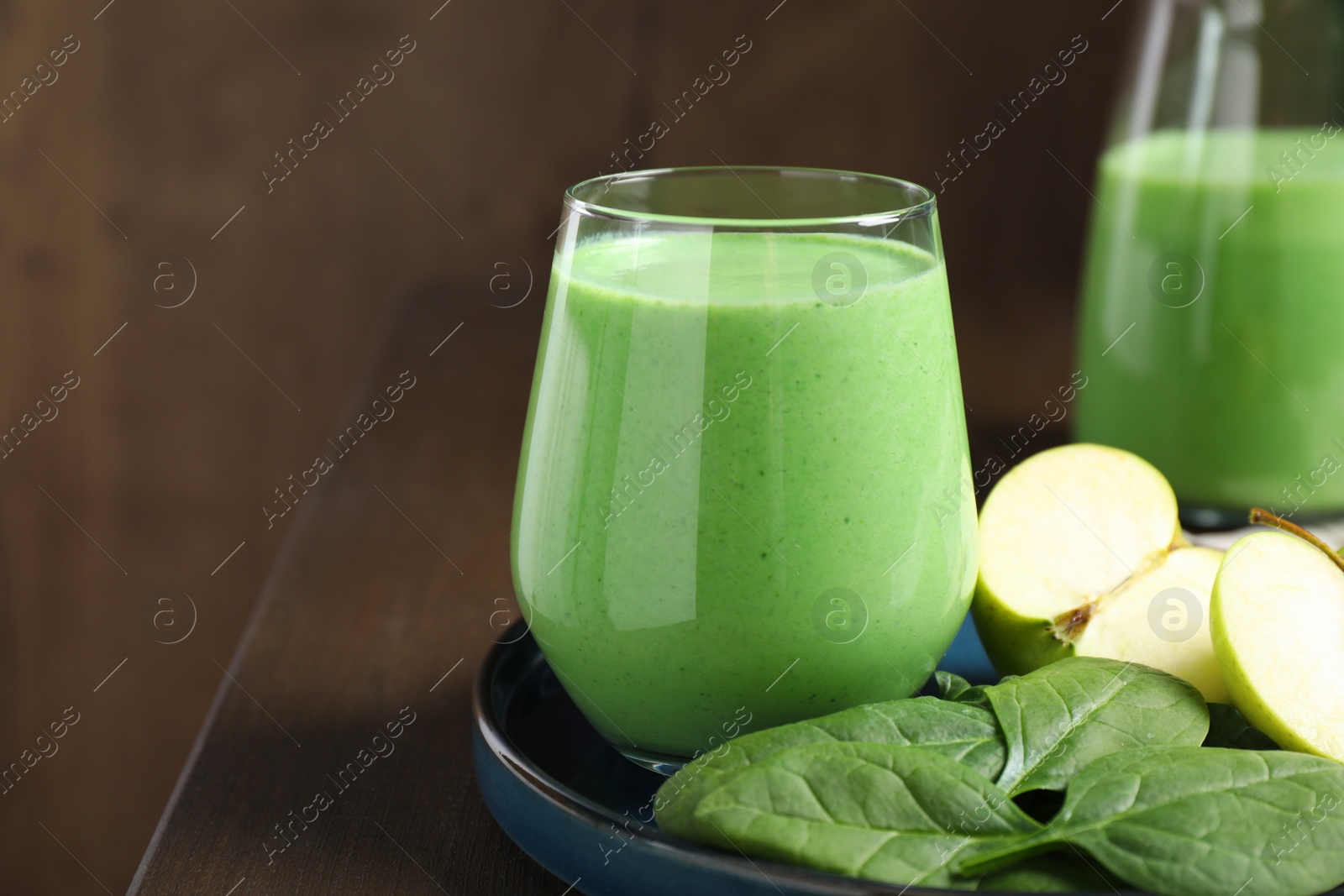 Photo of Tasty fresh spinach and apple smoothie on wooden table, space for text