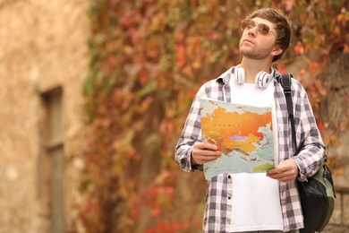 Photo of Traveler with world map near building outdoors