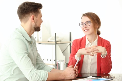 Photo of Man consulting with woman in office