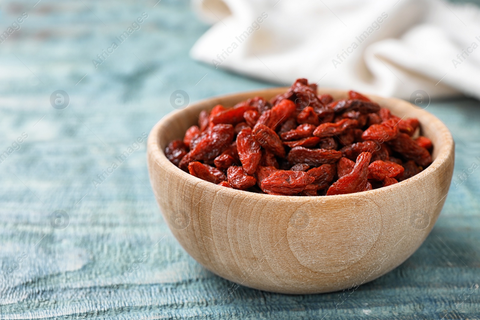 Photo of Dried goji berries on blue wooden table