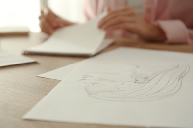 Photo of Pencil drawing of girl's portrait and blurred woman on background