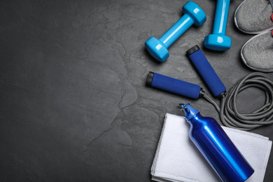 Photo of Gym equipment on black background, flat lay. Space for text