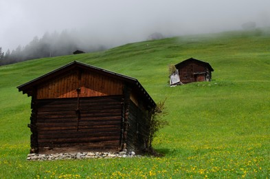 View of wooden houses on green hill