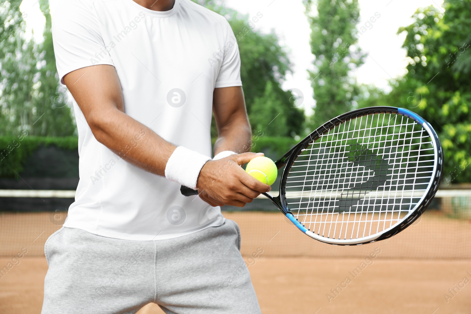 Photo of Sportsman preparing to serve tennis ball at court, closeup