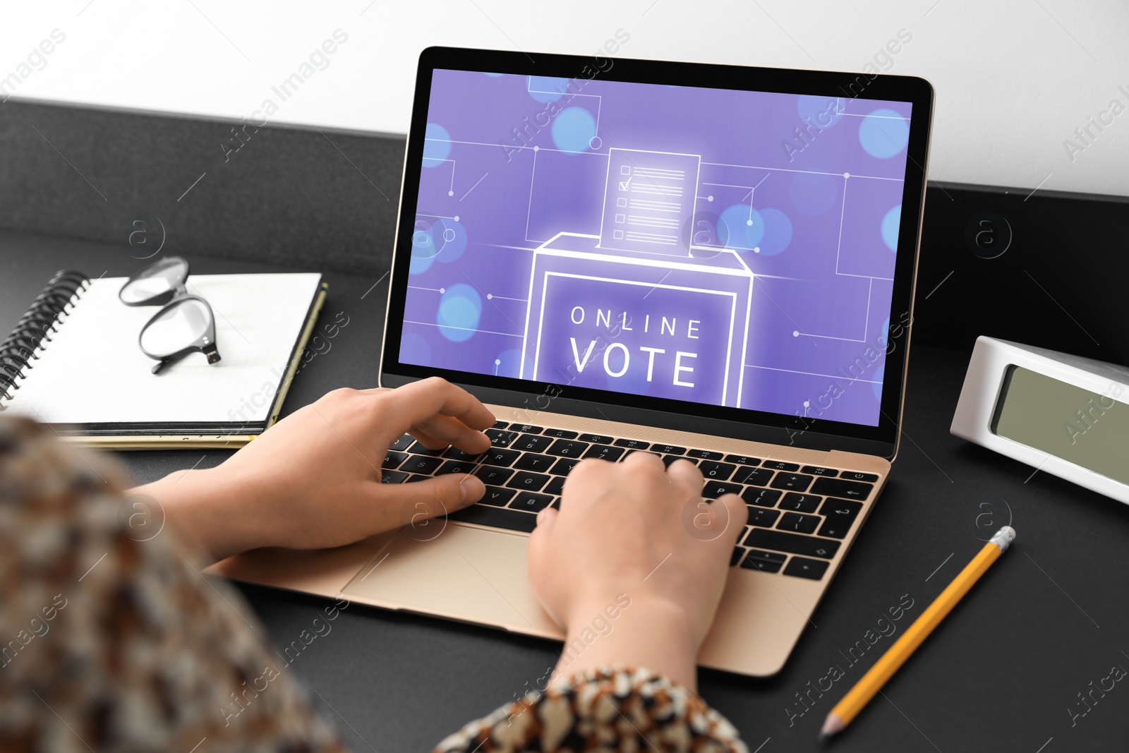 Image of Woman voting online via laptop at table, closeup